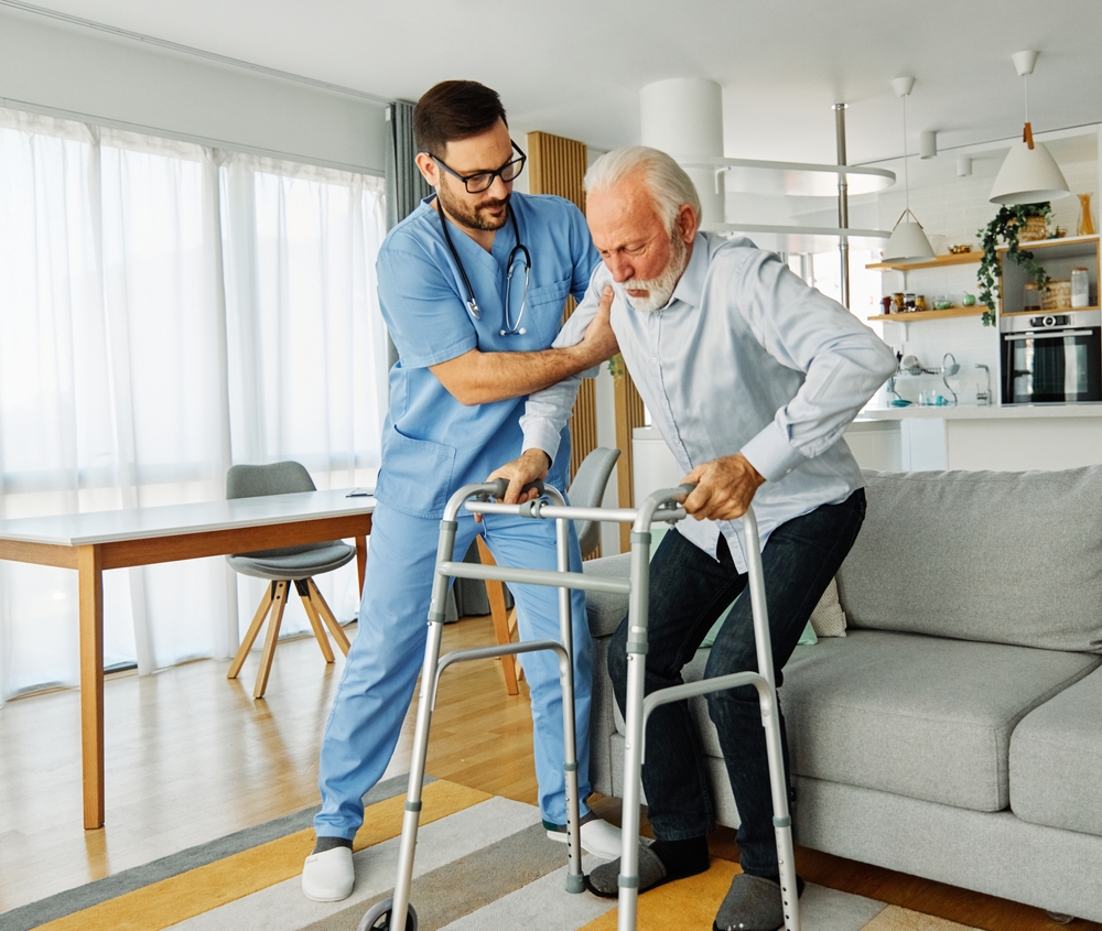 Compassionate Care. nurse helping elderly man walk