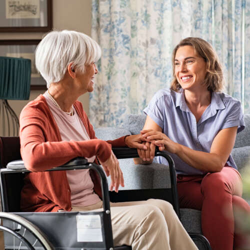 senior woman in wheel chair and nurse in a safe and comfortable home for seniors