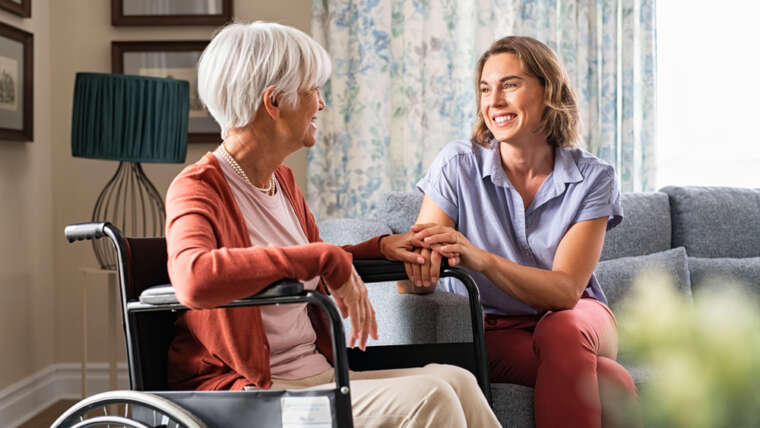 senior woman in wheel chair and nurse in a safe and comfortable home for seniors